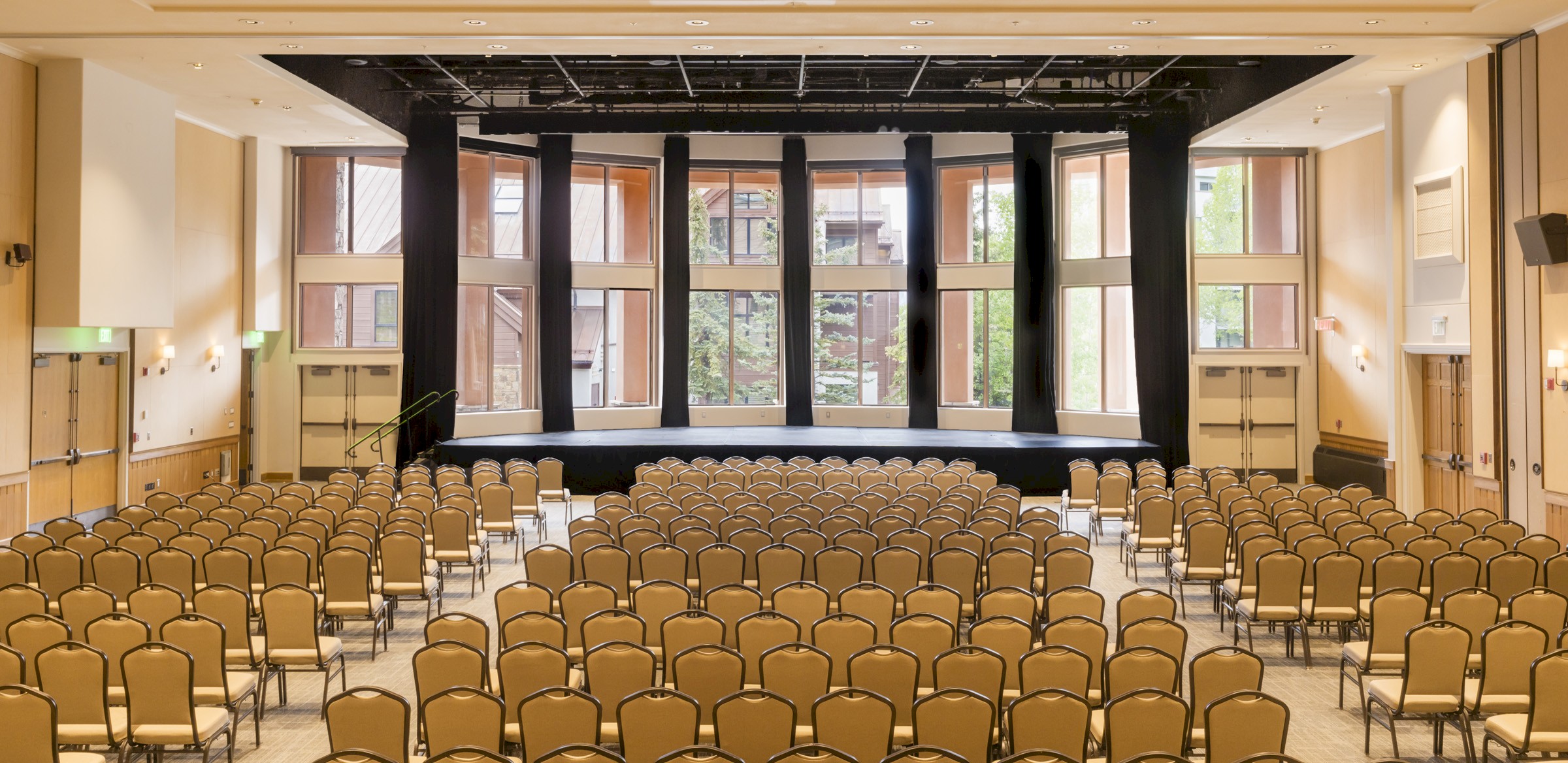 Conference room with chairs, tables and big screen on stage